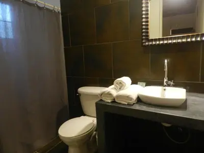 a bathroom with a toilet and a sink and a mirror at Atlakamani Surf in Chirilagua
