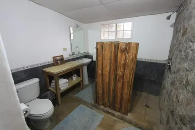 a bathroom with a wooden shower curtain and a toilet at Atlakamani Surf in Chirilagua