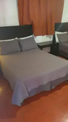 a large bed in a room with two tables at Atlakamani Surf in Chirilagua