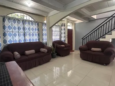 a living room with two couches and a staircase at Estancia Altos de Guadalupe in Alegría