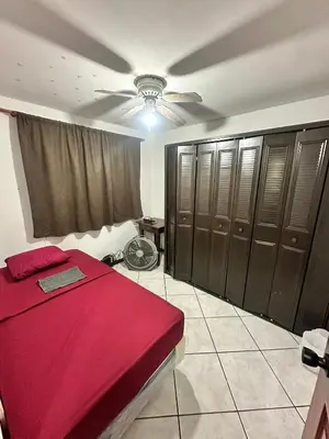 a bedroom with a red bed and a ceiling fan at Tu Estancia en San Salvador in Mexicanos