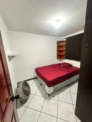 a bedroom with a red bed and a fan at Tu Estancia en San Salvador in Mexicanos