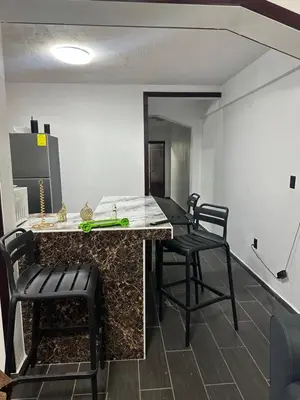 a kitchen with a counter and chairs in a room at Chavez in San Salvador