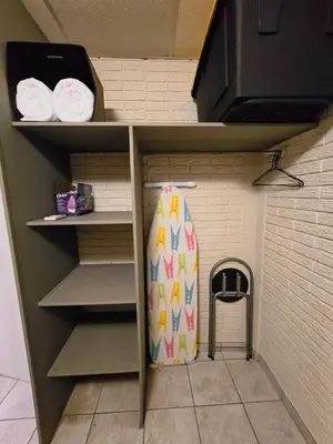a surfboard is sitting in a shelf in a closet at Cozy & Modern Condo In the Heart of San Salvador in San Salvador