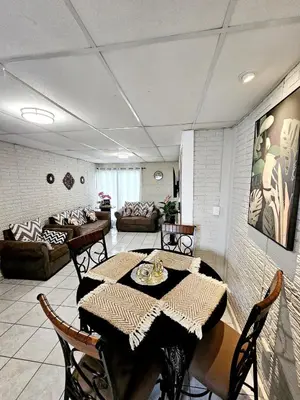 a dining room with a table and chairs and a living room at Cozy & Modern Condo In the Heart of San Salvador in San Salvador