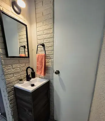 a bathroom with a sink and a mirror at Cozy & Modern Condo In the Heart of San Salvador in San Salvador