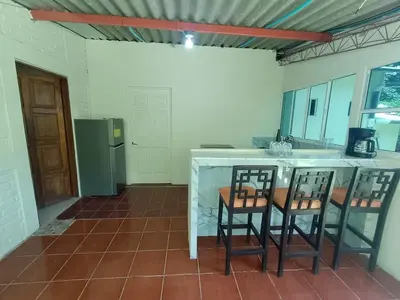 a kitchen with two chairs and a counter with a refrigerator at Casa Blanca el Zonte in El Zonte