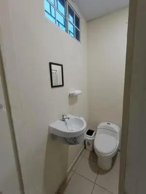 a white bathroom with a toilet and a sink at Casa Blanca el Zonte in El Zonte