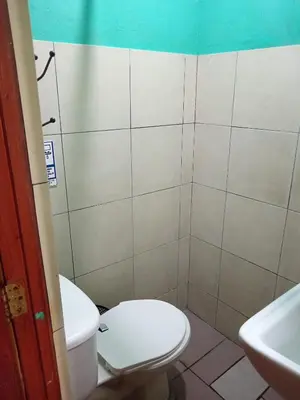 a bathroom with a toilet and a sink at Rooms libertad in San Salvador
