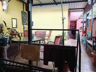 a patio with a table and chairs in a room at Rooms libertad in San Salvador
