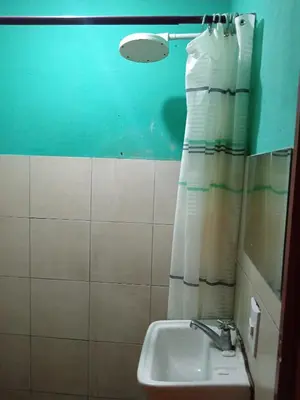 a bathroom with a sink and a shower curtain at Rooms libertad in San Salvador
