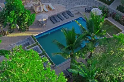 an overhead view of a swimming pool with palm trees at Hotel Termales La Montaña in Ahuachapán