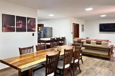 a dining room with a table and chairs and a couch at Hotel Termales La Montaña in Ahuachapán