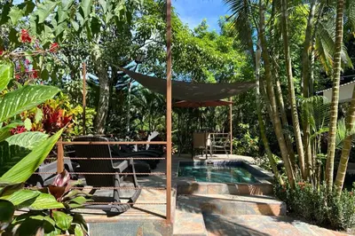 a pool with a umbrella and a table and chairs at Hotel Termales La Montaña in Ahuachapán