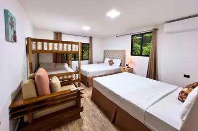 a bedroom with two beds and a bunk bed at Hotel Termales La Montaña in Ahuachapán