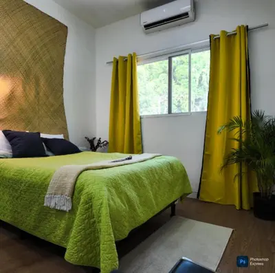a bedroom with a green bed with yellow curtains at Suite para dos Las Terrazas in San Salvador