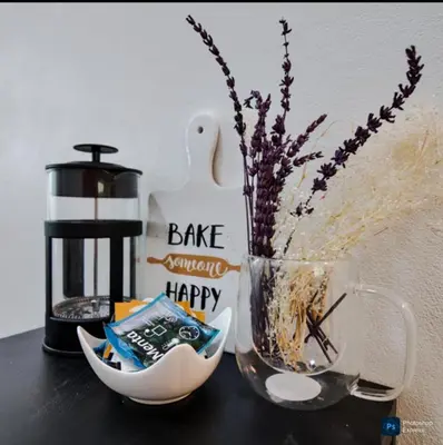 a coffee maker and a vase with flowers in it at Suite para dos Las Terrazas in San Salvador