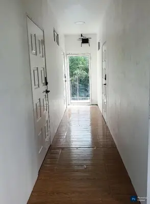 an empty hallway with an open door and a wooden floor at Suite para dos Las Terrazas in San Salvador