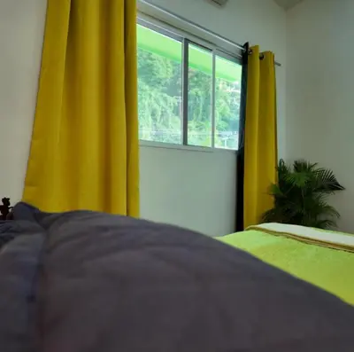 a bedroom with yellow curtains and a window at Suite para dos Las Terrazas in San Salvador