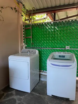 a washer and dryer sitting next to a green wall at La Casa de Sonya in Concepción de Ataco