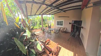 a screened in porch with a table and chairs at La Casa de Sonya in Concepción de Ataco