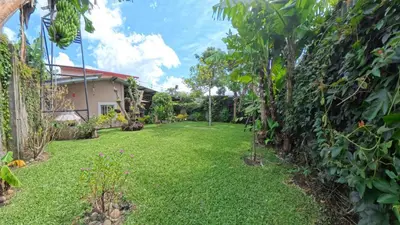 a yard with green grass and trees and a house at La Casa de Sonya in Concepción de Ataco