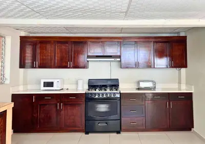 a kitchen with wooden cabinets and a stove top oven at Quinta Brisas del Surf La Libertad in La Libertad