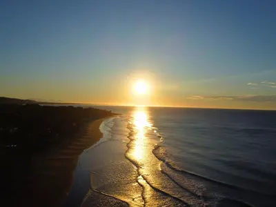 a sunset on a beach with the sun setting at Quinta Brisas del Surf La Libertad in La Libertad