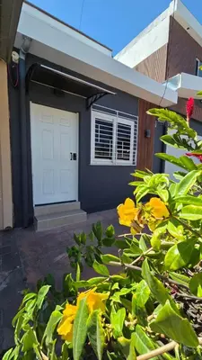 a house with a white door and some yellow flowers at Apartamento 2-B new suite in SS in San Salvador