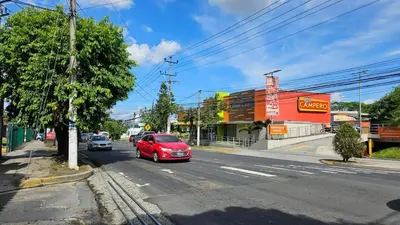a red car is driving down a street at Apartamento 2-B new suite in SS in San Salvador