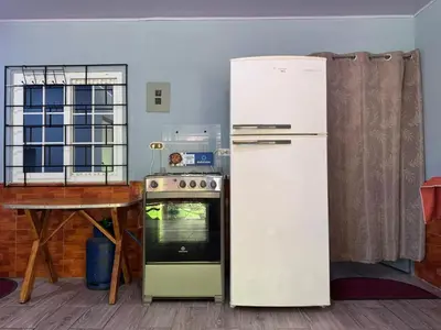 a white refrigerator in a kitchen with a table at Cocolandia Casa de campo cerca de Costa del sol en San Pedro Masahuat in San Pedro Masahuat