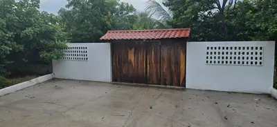 a garage with a wooden door and a fence at Cocolandia Casa de campo cerca de Costa del sol en San Pedro Masahuat in San Pedro Masahuat