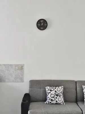 a clock hanging on a wall above a couch at Tu lugar tranquilo cerca de todo in San Miguel