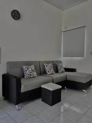 a living room with a couch and a clock on the wall at Tu lugar tranquilo cerca de todo in San Miguel