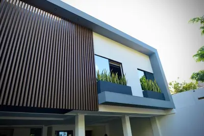 a building with two windows with plants in a balcony at Stylish apartment in San Salvador Downtown in San Salvador