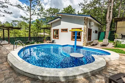a swimming pool with a house in the background at Bungalos Vista a Cayaguanca in San Ignacio