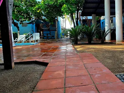 a red brick walkway with chairs and a building at Hotel y Restaurante Los Cobanos Village Lodge in Los Cóbanos