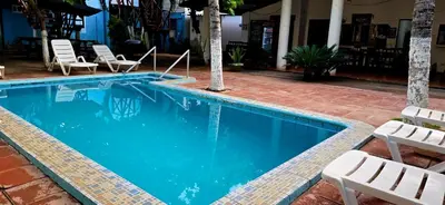 a swimming pool with chaise lounge chairs next to it at Hotel y Restaurante Los Cobanos Village Lodge in Los Cóbanos