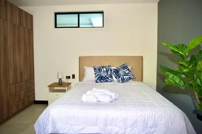 a bedroom with a bed with towels on it at Beautiful & Cozy Suite 3 min from Paseo Escalon in San Salvador