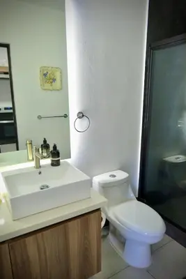a bathroom with a white sink and a toilet at Beautiful & Cozy Suite 3 min from Paseo Escalon in San Salvador