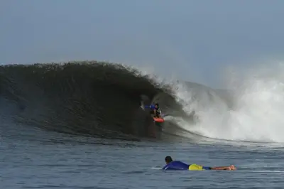 a man riding a wave on a surfboard in the ocean at Apt Playa kilometro 59, Rural area in ChiltiupÃ¡n