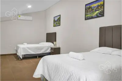 two beds in a room with white walls at Cozy Bedroom in a coffee farmn in Coatepeque Lake in Santa Ana