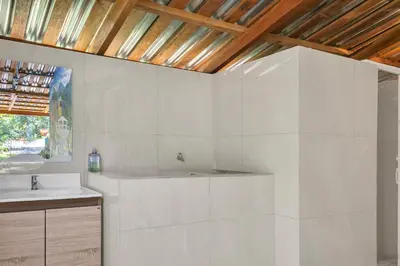 a white bathroom with a sink and a wooden ceiling at Cozy Bedroom in a coffee farmn in Coatepeque Lake in Santa Ana