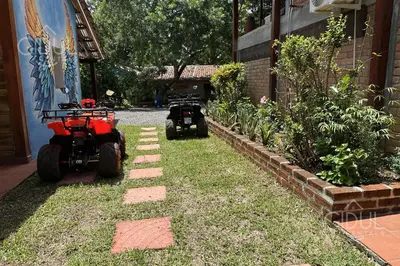 two tractors parked in a yard next to a building at Cozy Bedroom in a coffee farmn in Coatepeque Lake in Santa Ana