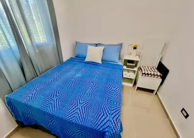 a bedroom with a blue bed and a window at Ahuachapan Tiny Rental Homes in Ahuachapán