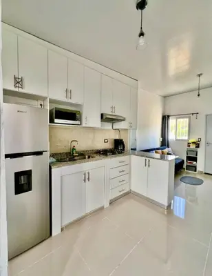 a large white kitchen with white cabinets and appliances at Ahuachapan Tiny Rental Homes in Ahuachapán