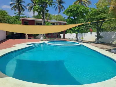 a large blue swimming pool with a hammock over it at Rancho número 50 in La Libertad