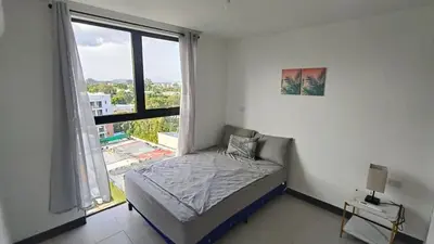 a bedroom with a bed and a large window at Vista de la capital in San Salvador