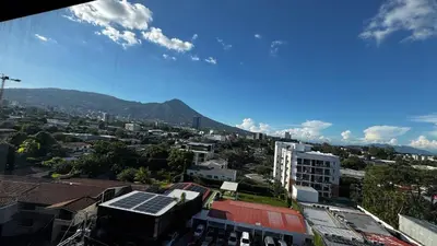 a view of a city with buildings and mountains at Vista de la capital in San Salvador