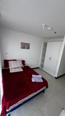 a bedroom with a bed with a red blanket at Vista de la capital in San Salvador